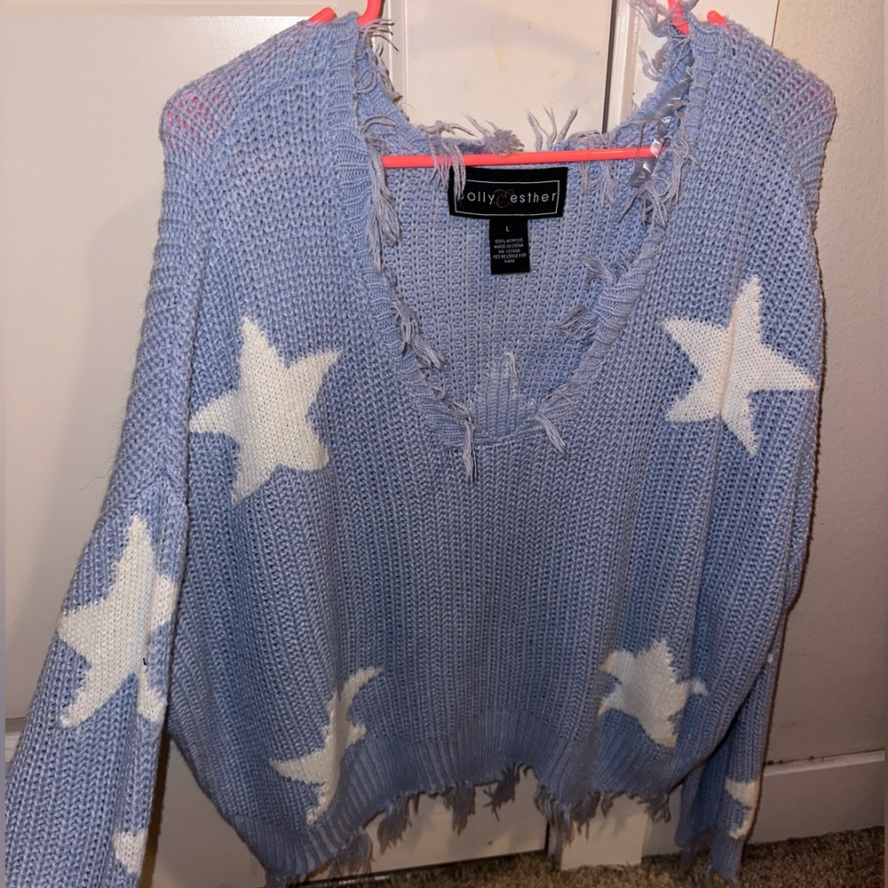 Light blue distressed sweater with white star detailing.